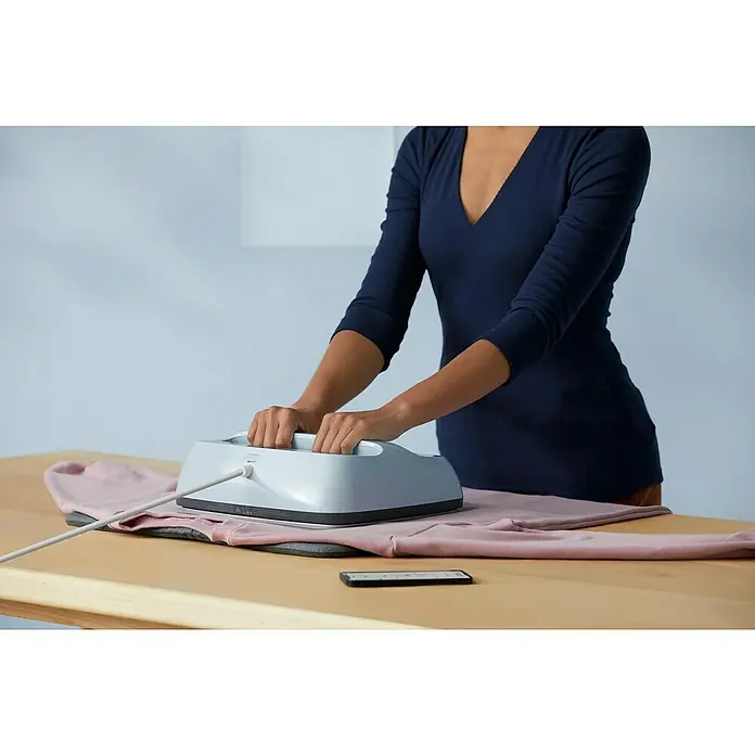 Cricut Transferpresse Easypress 3 - B x L: 30 x 25 cm, Passend für: Bügelfolien, Drucktechnologie: Wärmeübertragung - Nahaufnahme einer Person, die mit einer Cricut EasyPress auf einem rosa Sweatshirt arbeitet, um ein präzises und gleichmäßiges Bügelergebnis zu erzielen.