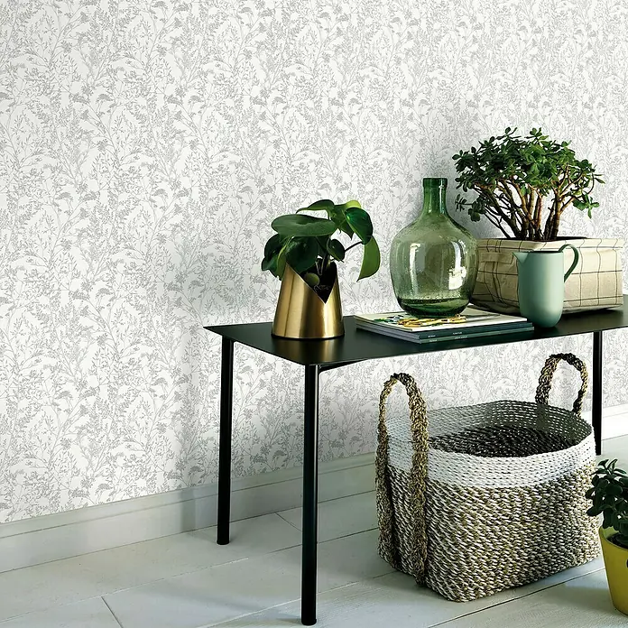 Papel pintado Vegetal - Blanco, Motivo decorativo, 10 x 0,53 m - Ambiente doméstico con consola negra, plantas en macetas, jarrón de vidrio verde y cesto de mimbre.