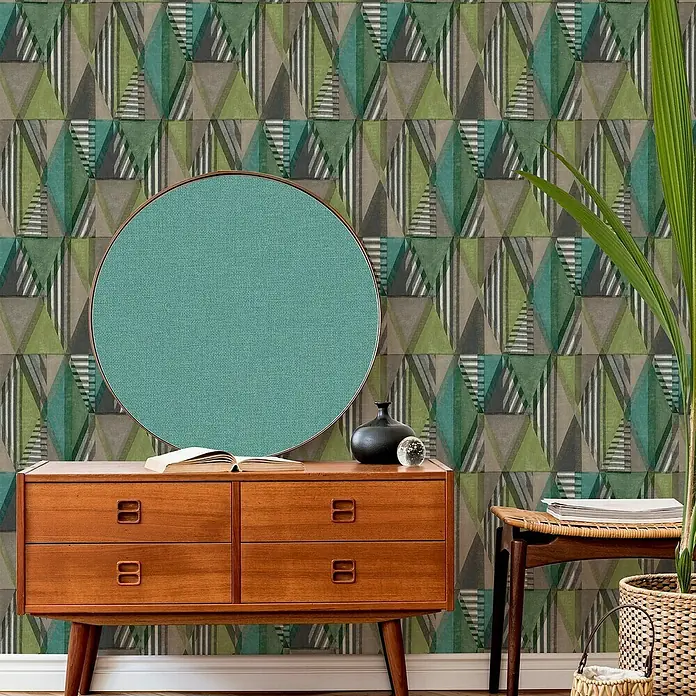 Papel pintado Geométrico Triángulos - Verde, Motivo decorativo, 10 x 0,53 m - Foto de interior con un espejo decorativo, una cómoda y una planta de interior sobre un fondo de pantalla geométrico.