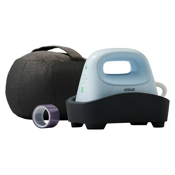 Cricut Transferpresse Hat Press - Passend für: Mützen, Drucktechnologie: Wärmeübertragung - Ein Cricut EasyPress Mini Bügeleisen mit Zubehör, ideal für kleine Bügelprojekte. Das blaue Gerät steht auf einer grauen Basis neben einer Tasche.