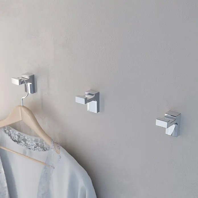 Creabath Elegance Colgador de baño - Número de ganchos: 1 ud., Cromo, Resplandeciente - Tres percheros de pared plateados modernos, uno con albornoz, que añaden un toque elegante a la habitación.