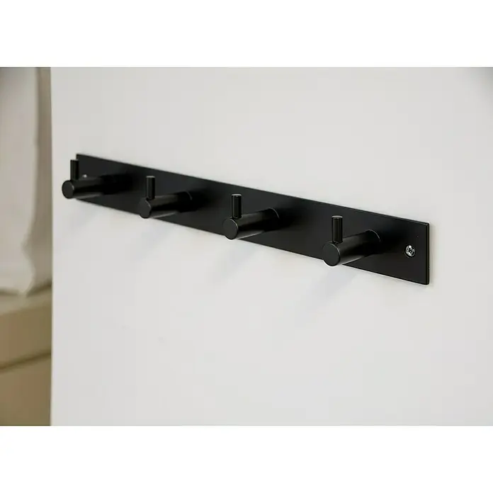 Siro Garderobenleiste 2452-322 - L x B x H: 322 x 38 x 43 mm, Anzahl Haken: 4 Stk., Schwarz - Eine moderne, mattschwarze Kleiderhakenleiste mit fünf Haken, die an einer weißen Wand montiert ist. Stilvolle und funktionale Wandgarderobe.