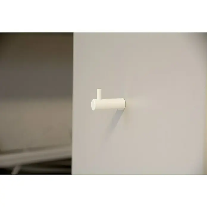 Siro Garderobenhaken - L x B x H: 40 x 14 x 28 mm, Weiß - Nahaufnahme eines weißen Wandhakens an einer hellgrauen Wand. Der Haken ist minimalistisch und zylindrisch geformt.