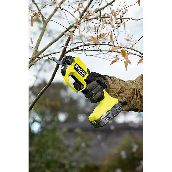 Ryobi ONE+ Maschinenpaket - Akku-Gartenschere RY18SCXA-0,18V, 4 Ah Akku & 2A Ladegerät - Eine gelbe Ryobi Akku-Astschere schneidet einen kleinen Ast an einem Baum.