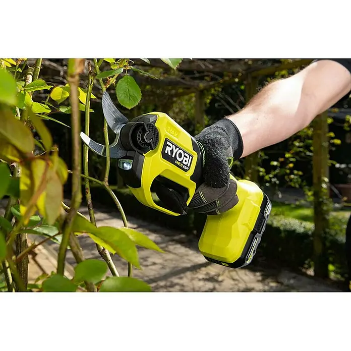 Ryobi ONE+ Maschinenpaket - Akku-Gartenschere RY18SCXA-0,18V, 4 Ah Akku & 2A Ladegerät - RYOBI ONE+ Akku-Gartenschere im Einsatz beim Beschneiden von Ästen, mit Akku und Handschuhen für den sicheren Gebrauch.