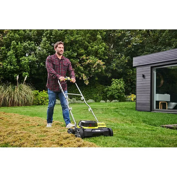 Ryobi ONE+ Escarificador de batería RY18SFX35A-0 - Número de baterías: Sin batería, 18 V, Anchura de trabajo: 35 cm - Un hombre usa un escarificador de césped Ryobi para cuidar su césped. El escarificador es amarillo y negro y tiene un mango plateado.