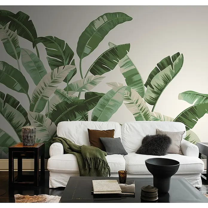 Rasch Florentine III Fototapete Palmblätter - B x H: 400 x 300 cm, Vlies, Grün - Das Wohnzimmer verfügt über eine botanische Tapete, ein weißes Sofa mit Kissen und einen schwarzen Couchtisch mit Dekorationsgegenständen.