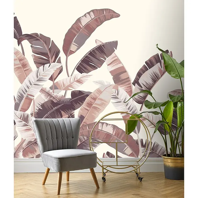 Rasch Florentine III Fototapete Palmblätter - B x H: 400 x 300 cm, Vlies, Terra - Ein stilvolles Interieur mit einem grauen Samtsessel und einem goldenen Barwagen vor einer Wand mit tropischen Blättern.