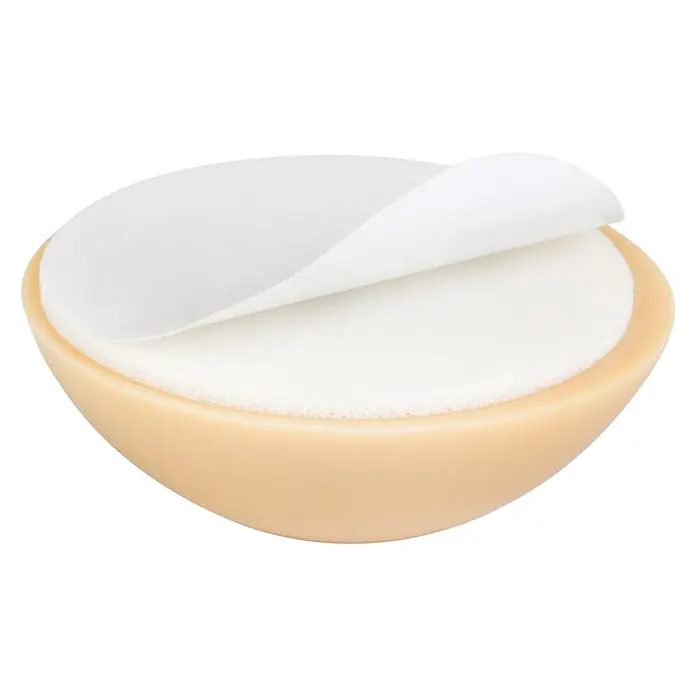 Walteco Türstopper - Ø x H: 30 x 12 mm, Beige, 2 Stk. - Nahaufnahme einer runden Kosmetik-Puderquaste in einer beigen Dose, mit einer abgezogenen Schutzfolie.