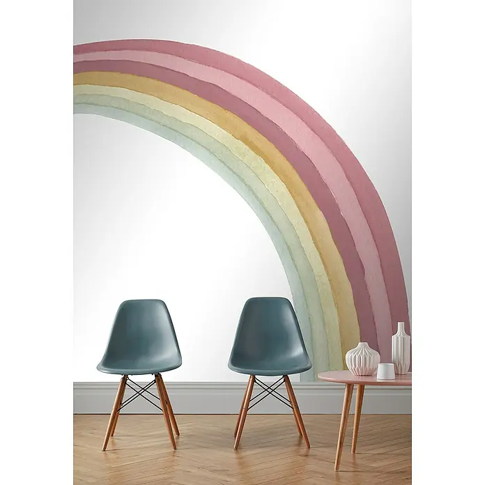 Rasch Bambino XIX Fototapete Regenbogen - B x H: 250 x 300 cm, Vlies, Rosa - Zwei blaue Stühle stehen vor einer Wand mit einem bunten Regenbogenmuster. Ein rosa Tisch mit Vasen ergänzt das Dekor des Zimmers.