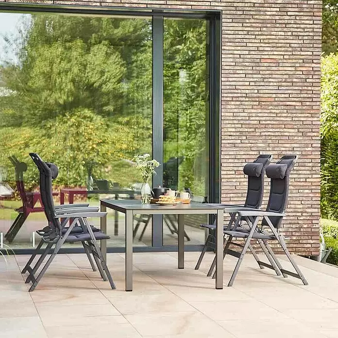Siena Garden Gartenmöbel-Set Premium/Sola - 5 -tlg., Schwarz/Anthrazit - Graues Metall-Gartenmöbel-Set mit rechteckigem Tisch und vier Klappstühlen auf einer Terrasse.