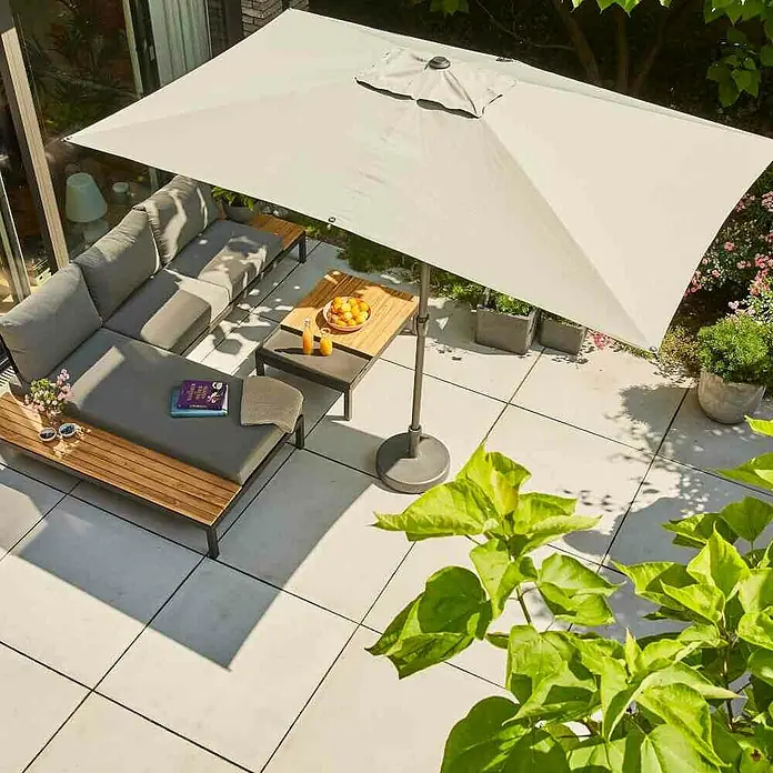 Siena Garden Loungemöbel-Set Alvida/Isa - 3 -tlg., Anthrazit/Schwarz, Teakholz, 3 - Eine rechteckige, cremefarbene Sonnenschirm, der eine Terrasse mit grauen Lounge-Möbeln und einem Holztisch beschattet.