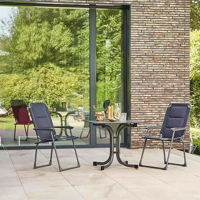 Siena Garden Gartenmöbel-Set Premium/Sola - 3 -tlg., Schwarz/Anthrazit, Aluminium - Zwei dunkelgraue Gartenstühle und ein passender Tisch auf einer gefliesten Terrasse im Garten.