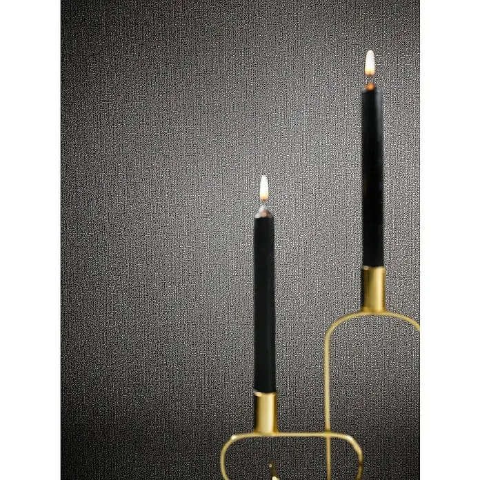 Marburg Papis Loveday Vliestapete - Anthrazit, Uni, 10,05 x 0,7 m - Kerzenständer mit schlanken, schwarzen Kerzen, die in einem minimalistischen, goldenen Halter auf einem strukturierten Hintergrund stehen.