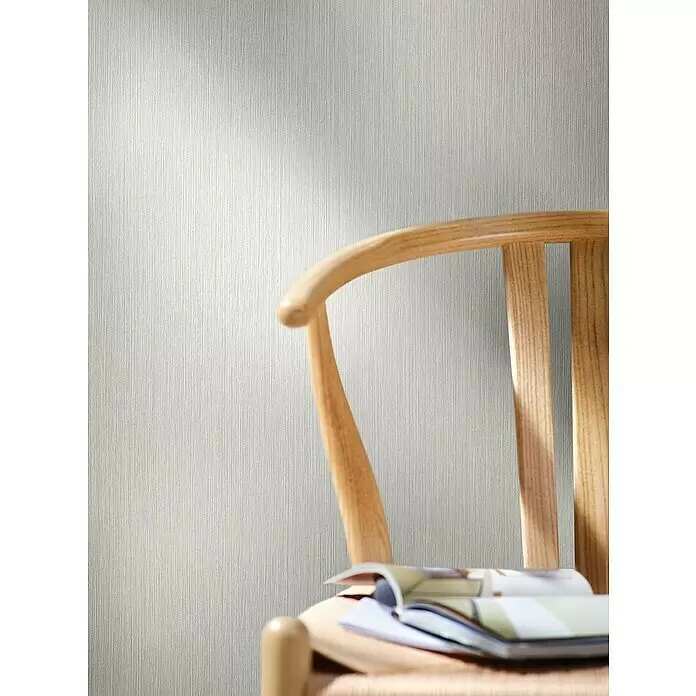Marburg Papis Loveday Vliestapete - Beige, Grafisch, 10,05 x 0,7 m - Helle, vertikal texturierte Tapete an einer Wand, sichtbar hinter einem Holzstuhl.