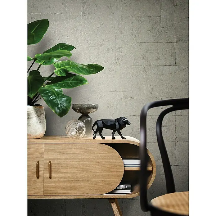 Marburg Papis Loveday Vliestapete I - Beigegrau, Grafisch, 10,05 x 0,7 m - Elegantes Sideboard aus hellem Holz mit stilvollen Akzenten, verziert mit dekorativen Elementen wie einer modernen Löwenfigur und einer Pflanze.