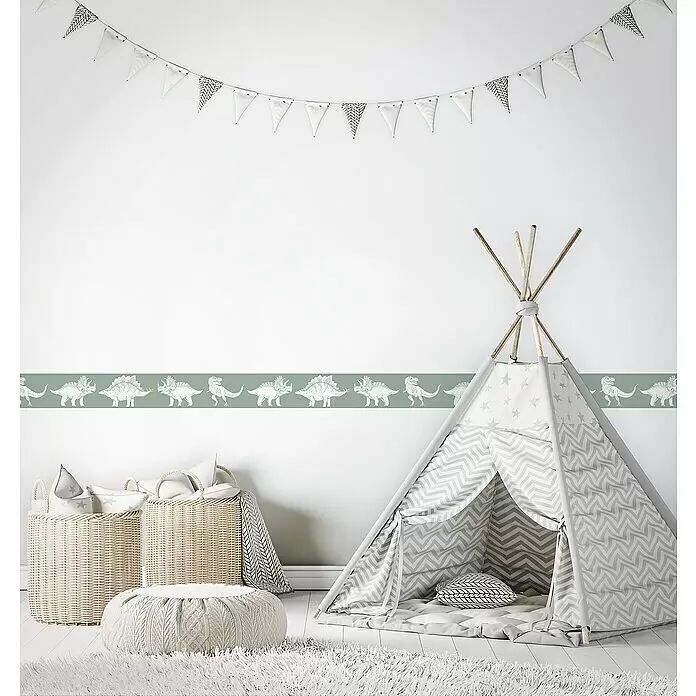 Marburg Kids' Walls Tapetenborte Dinosaurier - Kunststoff, Grün - Gemütliches Kinderzimmer mit grau-weißem Tipi, Korbtaschen, Strick-Pouf und Dinosaurus-Wandbordüre. Girlande hängt oben.