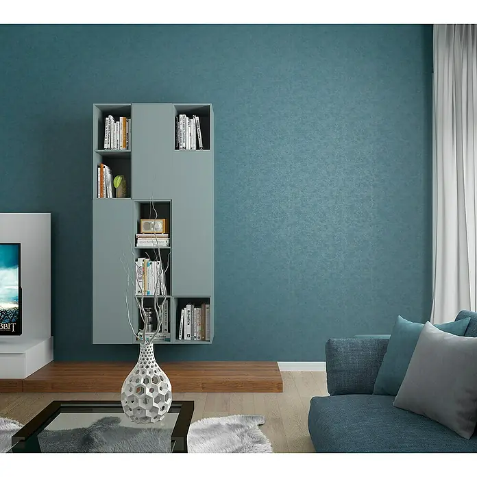 Marburg Kids' Walls Vliestapete schattiert - Blaugrün, Uni, 10,05 x 0,53 m - Ein Bücherregal in einem Wohnzimmer mit Büchern, Dekorationen und einer modernen Vase auf einem Couchtisch.
