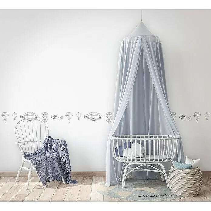 Marburg Kids' Walls Tapetenborte Luftschiffe - Kunststoff, Weiß/Schwarz - Weißes Rattan-Babybett mit hellblauem, transparentem Betthimmel in einem Kinderzimmer.