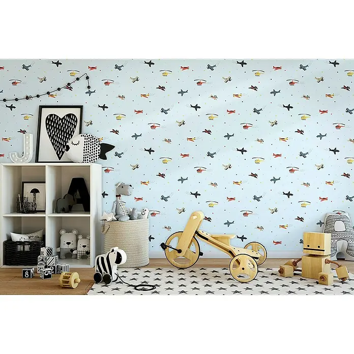 Marburg Kids' Walls Vliestapete Flugzeuge - Blau/Multicolor, Grafisch, 10,05 x 0,53 m - Kinderzimmer mit einer blauen Tapete mit Flugzeugmuster, einem weißen Regal und verschiedenen Spielzeugen.