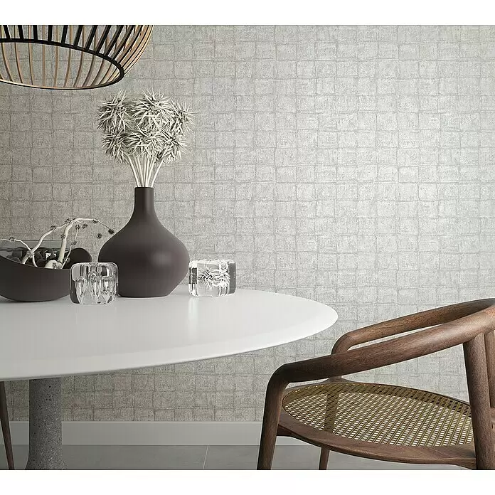 Marburg Botanica Vliestapete - Grau, Fliesenoptik, 10,05 x 0,53 m - Ein moderner Esszimmerstuhl aus dunklem Holz mit Wiener Geflecht, steht neben einem weißen Tisch.