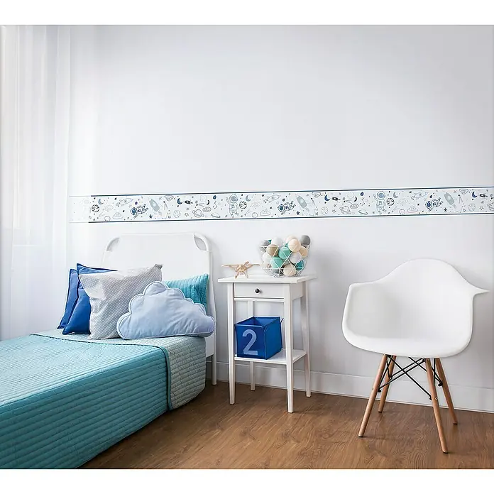 Marburg Kids' Walls Tapetenborte Astronaut - Kunststoff, Weiß/Blau - Kinderzimmer mit blauem Bett, weißem Nachttisch und Stuhl. An der Wand befindet sich eine Bordüre mit Weltraummotiven, die dem Raum eine spielerische Note verleiht.