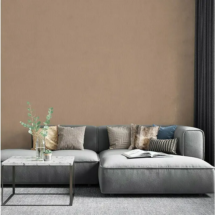 Marburg Botanica Vliestapete - Beige/Braun, Uni, 10,05 x 0,53 m - Gemütliches Wohnzimmer mit einem grauen Ecksofa, Kissen und einem Couchtisch mit Dekorationen. Eine einladende Atmosphäre zum Entspannen.