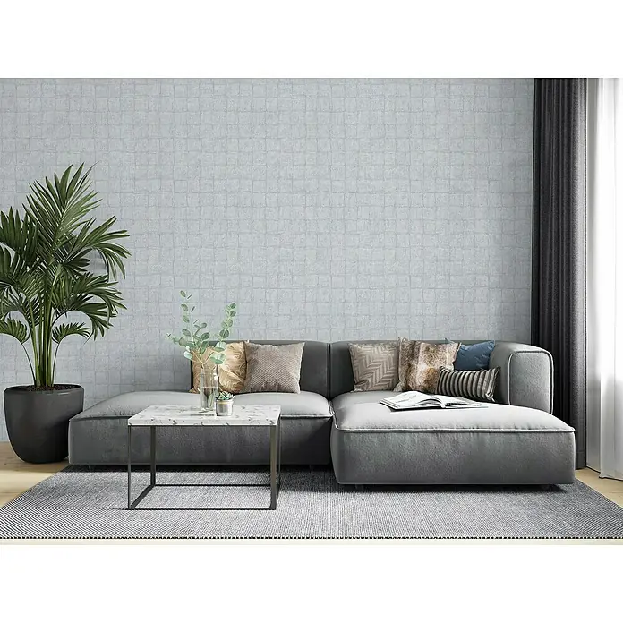 Marburg Botanica Vliestapete - Blau/Grau, Fliesenoptik, 10,05 x 0,53 m - Ein stilvolles Wohnzimmer mit einer grauen Couch, einem Marmortisch und einer Zimmerpflanze, die für eine moderne Atmosphäre sorgen.