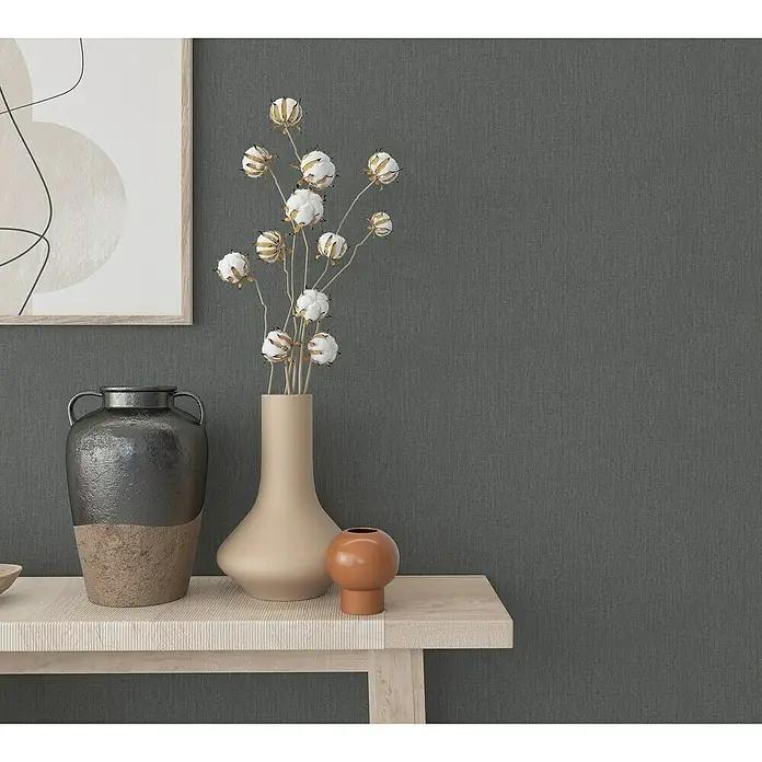 Marburg Botanica Vliestapete - Dunkelgrau, Uni, 10,05 x 0,53 m - Stillleben mit einer grauen Wand, einer Kommode, einer Vase, Baumwollzweigen und einer Grafik an der Wand für ein ruhiges Ambiente.