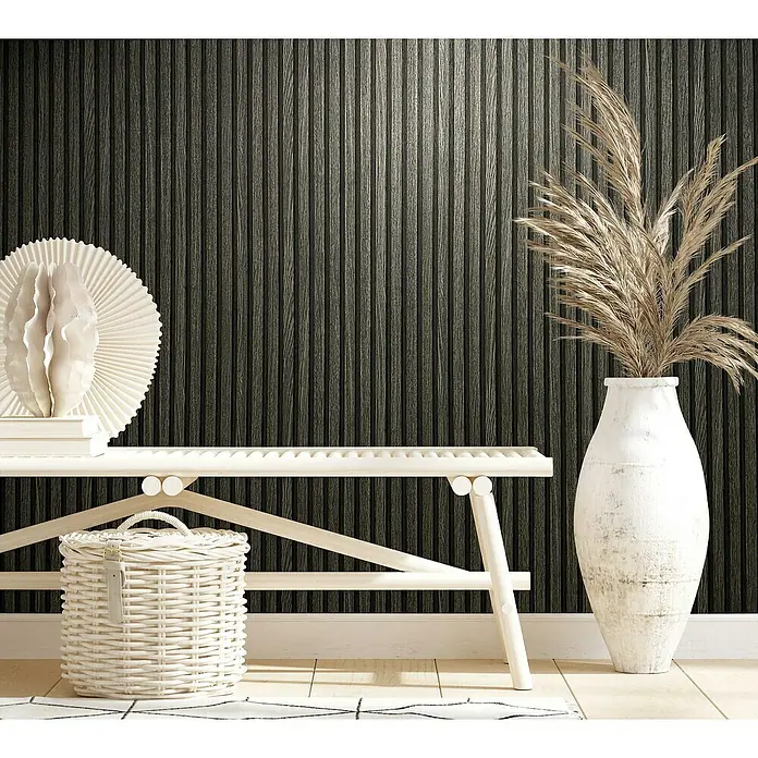 Marburg Botanica Vliestapete Wandpaneele - Schwarz/Anthrazit, Holzoptik, 10,05 x 0,53 m - Nahaufnahme eines stilvollen Raumes mit einer weißen Bank, einer dekorativen Vase mit Pflanzen und einem geflochtenen Korb, der eine ruhige Atmosphäre ausstrahlt.