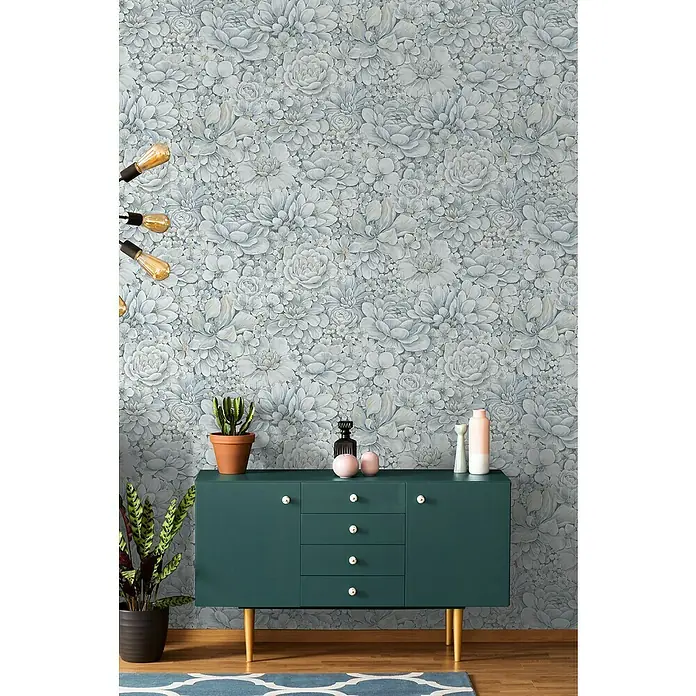 Marburg Botanica Vliestapete - Blau/Grau, Floral, 10,05 x 0,53 m - Nahaufnahme eines grünen Sideboards mit Dekorationen vor einer floralen Tapete, die eine gemütliche und stilvolle Atmosphäre schafft.