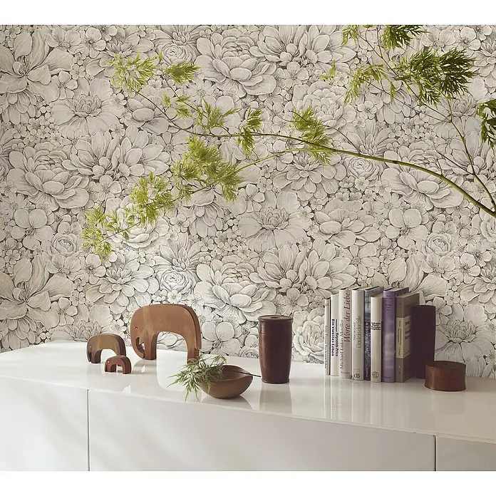 Marburg Botanica Vliestapete - Greige, Floral, 10,05 x 0,53 m - Elegantes Stillleben mit floraler Tapete, Holzelefanten und einer Sammlung von Büchern auf einem weißen Sideboard.
