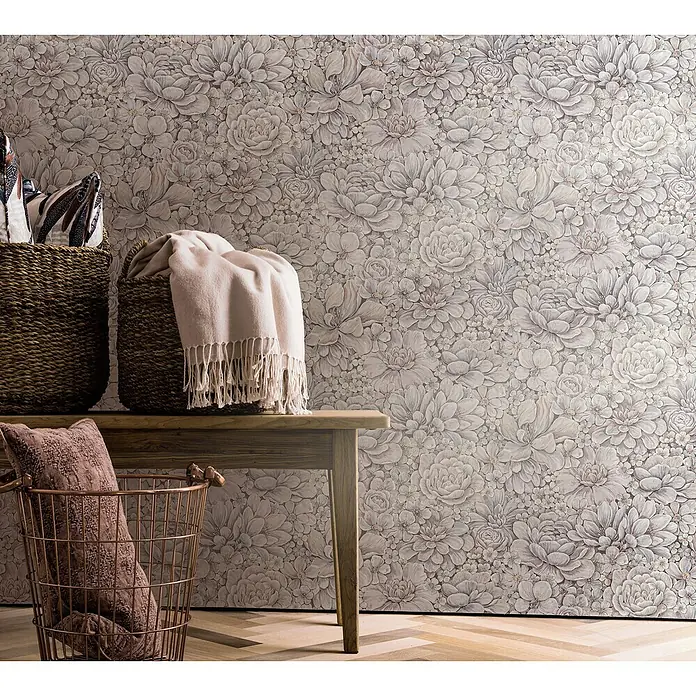 Marburg Botanica Vliestapete - Rosa/Grau, Floral, 10,05 x 0,53 m - Elegantes Interieur mit Korbmöbeln und einer Bank vor einer floralen Tapete, die eine gemütliche und stilvolle Atmosphäre schafft.