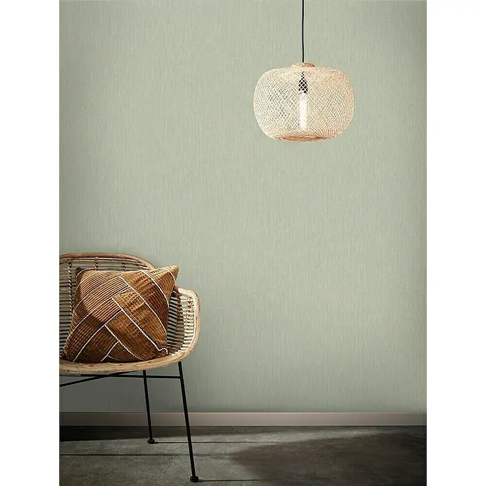 Marburg Botanica Vliestapete Struktur - Grün, Uni, 10,05 x 0,53 m - Eine gemütliche Szene mit einer Rattan-Lampe und einem Rattan-Stuhl, die eine warme und einladende Atmosphäre schafft.