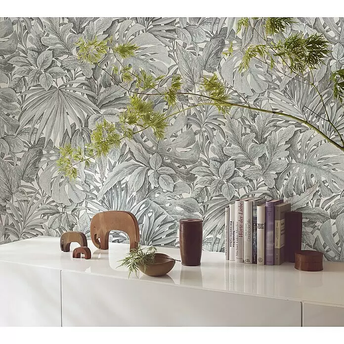 Marburg Botanica Vliestapete - Weiß/Grün, Floral, 10,05 x 0,53 m - Tapete mit tropischem Blattmuster in Hellgrau- und Grüntönen, an einer Wand hinter einem weißen Schrank mit Deko.