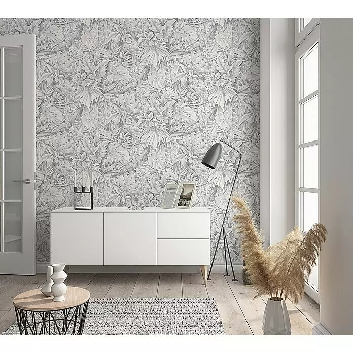 Marburg Botanica Vliestapete - Hellgrau, Floral, 10,05 x 0,53 m - Grau-weiße Tapete mit tropischem Blättermuster an einer Wand in einem Raum, die eine lebendige Kulisse schafft.