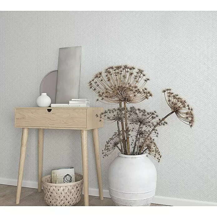 Marburg Botanica Vliestapete Allover - Weiß, Grafisch, 10,05 x 0,53 m - Eine helle Holzkonsole mit Schublade, dekoriert mit minimalistischem Dekor und Trockenpflanzen.