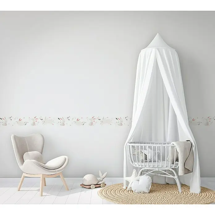 Marburg Kids' Walls Tapetenborte Häschen - Kunststoff, Weiß/Rosa - Babyzimmer mit einem Wandbord mit Hasenmotiv, einem weißen Kinderbett mit Baldachin und einem bequemen Sessel. Ideal für eine liebevolle Gestaltung.