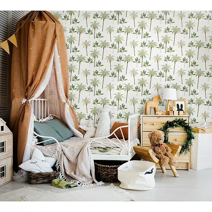 Marburg Kids' Walls Vliestapete Palmen - Weiß/Grün, Tieroptik, 10,05 x 0,53 m - Weißes sternförmiges Textilkissen mit aufgestickten geschlossenen Augen, als Teil der Kinderzimmerdekoration, in einem Korb neben einem Bett.