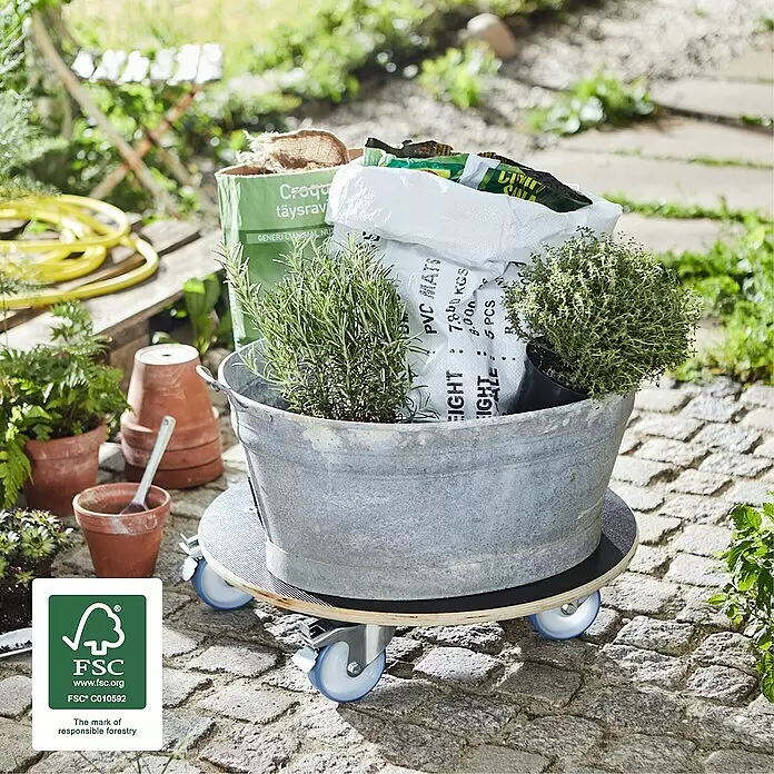 Wagner System Pflanzenroller XXL Grip - 58 cm, Max. Belastung: 300 kg - Runder Pflanzenroller aus Holz mit blauen Rollen trägt einen Metallbottich mit Kräutern und Gartenzubehör in einem Garten.