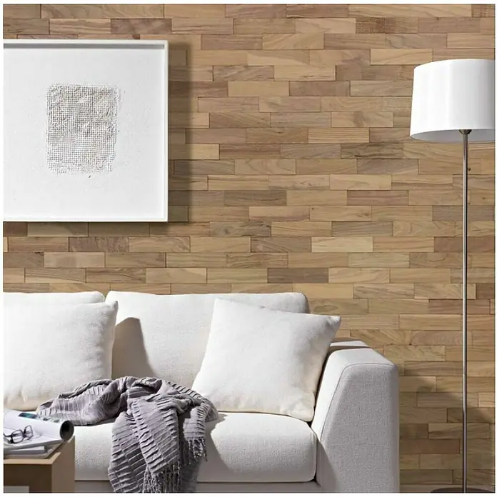 Wodewa Holzriemchen 200 Nussbaum - 100 Stk., L x B: 200 x 50 mm, 2 mm - 6 mm, Max. Anwendungsfläche: 1 m², Unbehandelt - Ein stilvolles Wohnzimmer mit einer Wand aus Holzpaneelen, einem weißen Sofa und einer Stehlampe, die eine warme Atmosphäre schaffen.