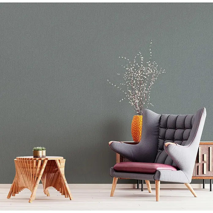 Marburg Kids' Walls Vliestapete - Dunkelgrau, Uni, 10,05 x 0,53 m - Elegantes Interieur mit einem stilvollen Sessel, einem Beistelltisch und einer dekorativen Vase, die ein gemütliches Ambiente schaffen.