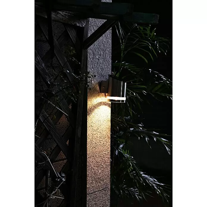 BAUHAUS Solar-Außenwandleuchte - 0,1 W, L x B x H: 12 x 9 x 12,5 cm, Silber, 15 lm - Wandmontierte Außenleuchte aus Edelstahl auf einem Steinpfeiler, die dessen strukturierte Oberfläche nachts warm beleuchtet.