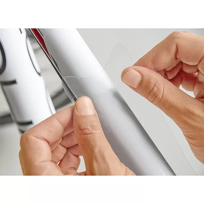 Luxshield Lackschutzfolie für Fahrräder - 5 -tlg. - Hände bringen transparente Schutzfolie auf ein weißes zylindrisches Objekt auf.