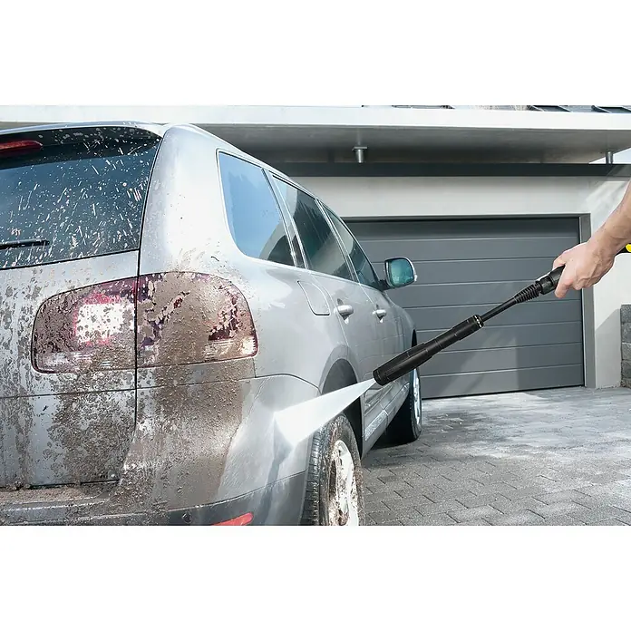 Kärcher Hidrolimpiadora de alta presión K4 Universal Edition - 130 bar, 1.800 W, Capacidad de bombeo: 420 l/h - Un SUV plateado está siendo limpiado de suciedad con una hidrolavadora Kärcher, mostrando su poder de limpieza.