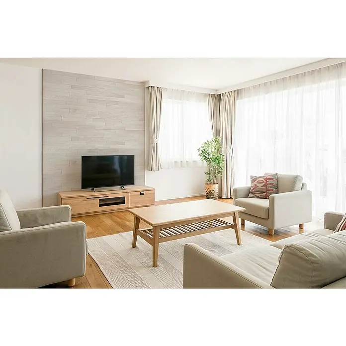Wodewa Holzriemchen 1000 Eiche Arctic - 1.000 x 100 mm, Stärke: 3 mm - 6 mm, 10 Stk., 1 m², Verklebung - Ein helles Wohnzimmer mit einem Holz-TV-Schrank, einem Couchtisch und bequemen Sesseln, die eine gemütliche Atmosphäre schaffen.