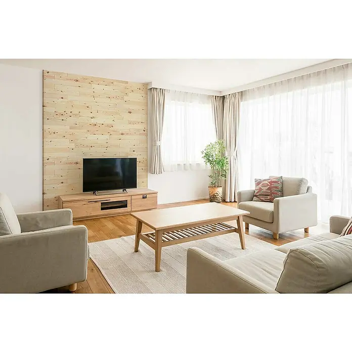 Wodewa Holzriemchen 1000 Zirbe - 1.000 x 100 mm, Stärke: 3 mm - 6 mm, 10 Stk., 1 m², Selbsklebend - Ein helles Wohnzimmer mit Holzmöbeln, einem TV-Gerät und bequemen Sesseln, ideal für entspannte Stunden zu Hause.