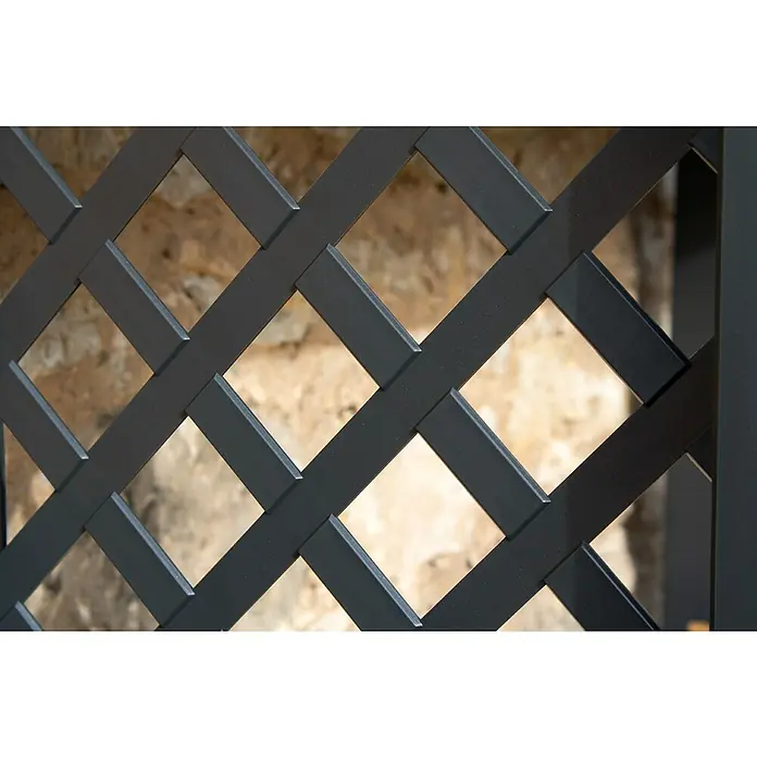 KHW Kaminholzregal - 114 x 47 x 102 cm, Kunststoff, Anthrazit - Nahaufnahme eines schwarzen Metallgitterzauns mit einem Hintergrund aus beigem Mauerwerk, der die Geometrie und Textur des Zauns hervorhebt.