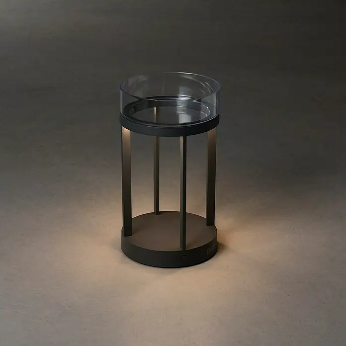 Konstsmide Außenlaterne Chieti - 17 x 17 x 25 cm, Grau - Elegante zylinderförmige Tischleuchte mit transparentem Lampenschirm und schlanken, modernen Metallelementen, die ein sanftes Licht ausstrahlt.