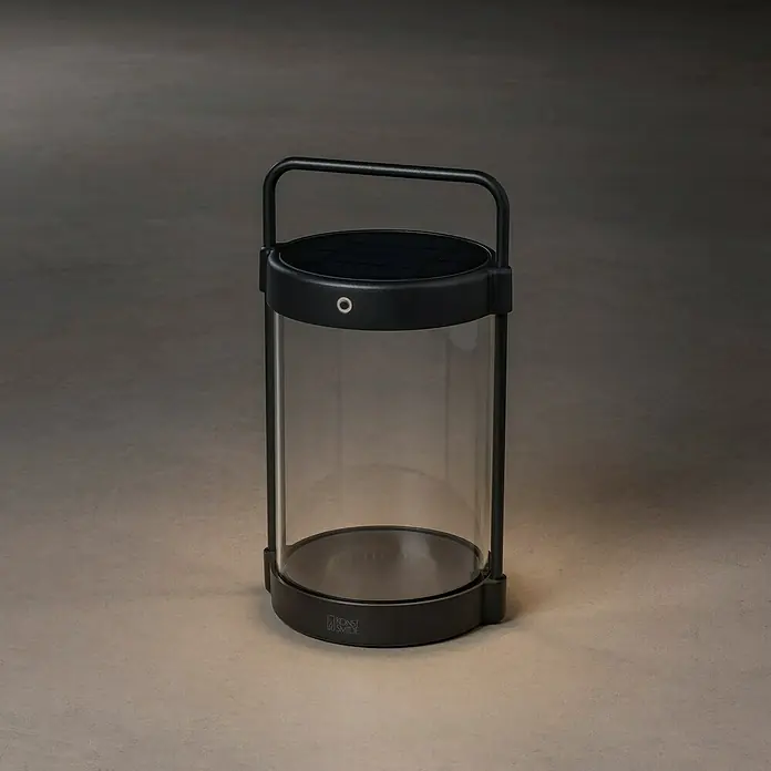 Konstsmide Außenlaterne Crotone - 17 x 15 x 30 cm, Schwarz - Eine moderne, tragbare Laterne mit einem transparenten Zylinder und einem schwarzen Metallrahmen, ideal für Innen- und Außenbereiche.
